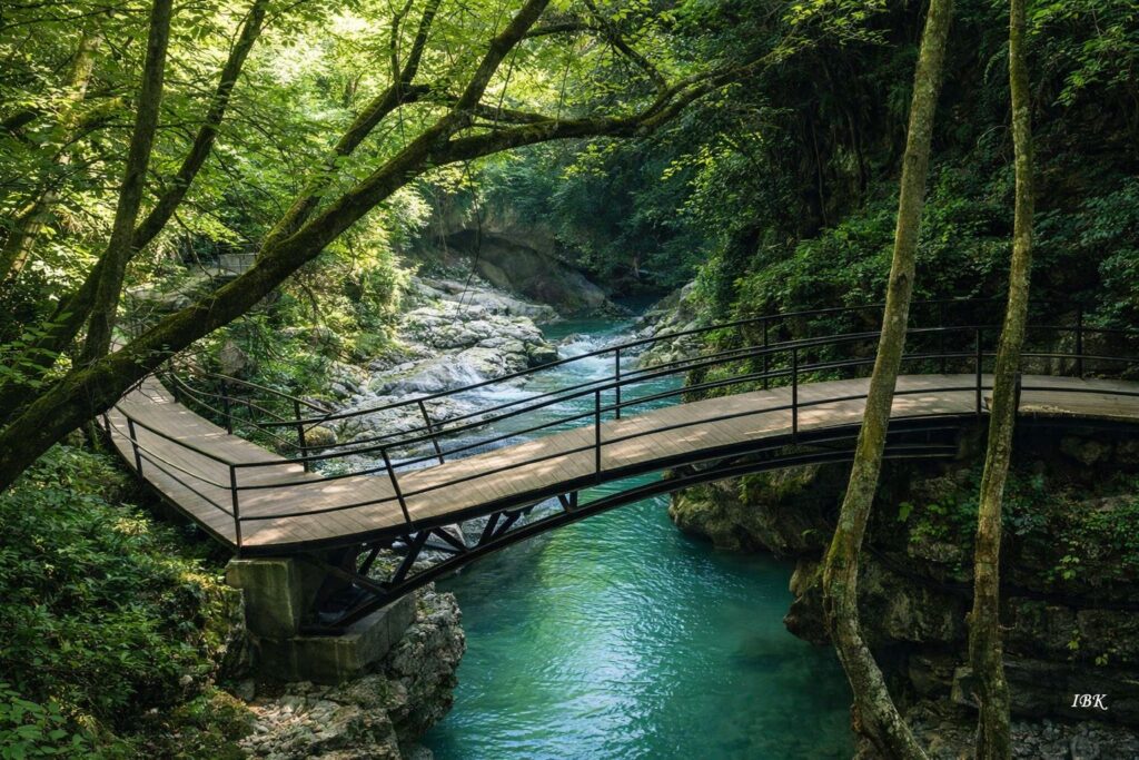 Okaze Kanyon in Westgeorgien mit türkisfarbenem Fluss, Fußgängerbrücke und dichter grüner Vegetation